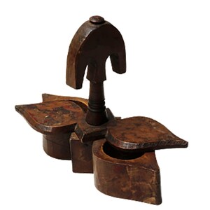 May include: A wooden spice box with three compartments, each shaped like a leaf. The box has a decorative top with a knob. The box is made of dark brown wood and has a rustic appearance.