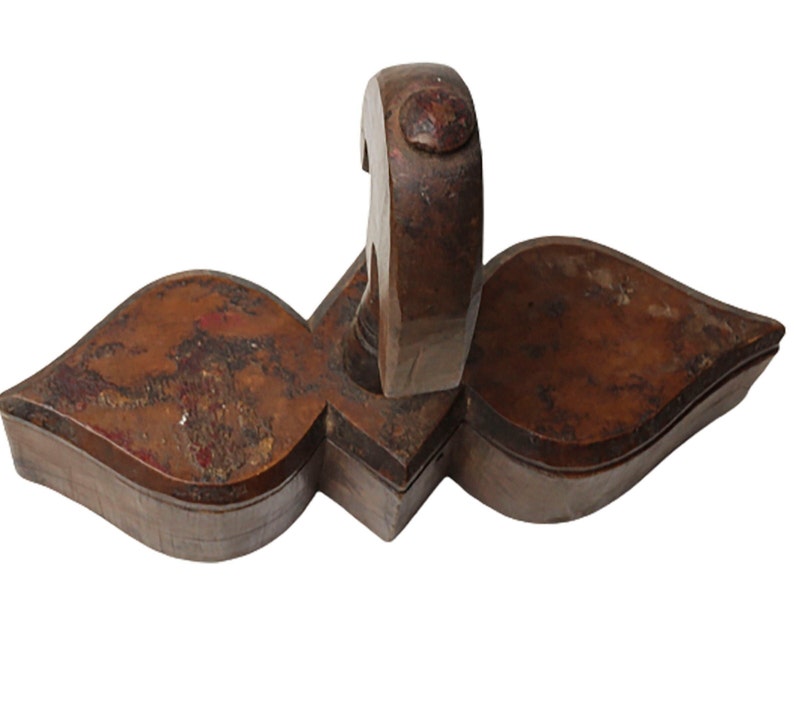 May include: A wooden box with a unique shape, resembling a heart with a handle. The box is made of dark brown wood with a worn, rustic finish.