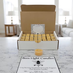 May include: A box of beeswax candles with a single candle in front. The box is open, revealing rows of small, square candles. The text "Bees Light Candles" is visible on a sign below the candles.