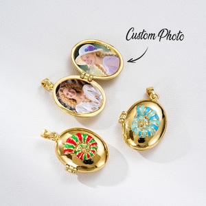 Puede incluir: Medallones ovalados dorados, algunos abiertos para revelar fotos. Uno presenta un diseño rojo y verde, otro un diseño azul y turquesa. El texto "Custom Photo" está escrito encima de uno de los medallones.