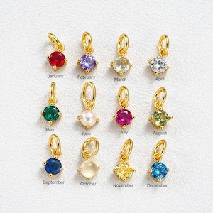 May include: Gold-plated pendants featuring birthstones in a range of colours, such as red, purple, and green. Each pendant has a small loop for attaching to a chain. The months of the year are labelled below each pendant.