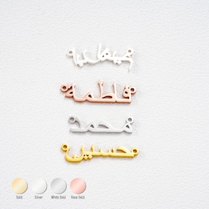 May include: Four name pendants in gold, silver, white gold, and rose gold. The pendants are written in Arabic script. The gold pendant is at the bottom, the silver pendant is in the middle, the white gold pendant is at the top, and the rose gold pendant is in the middle.