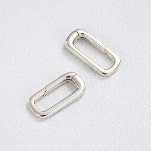 Puede incluir: Dos conectores de cierre rectangulares de color plateado. Los cierres están hechos de un metal brillante y tienen una superficie lisa y pulida. Los cierres están diseñados para conectar dos piezas. El fondo es una superficie clara y texturizada.