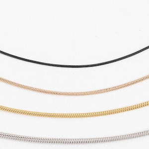 May include: Four different types of chain necklaces, including black, rose gold, gold, and silver.