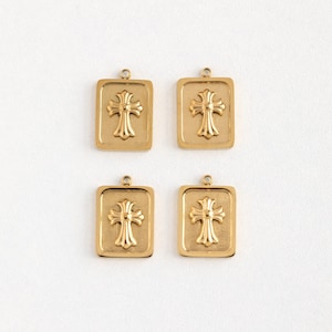 Puede incluir: Cuatro colgantes de oro, cada uno con un marco cuadrado con un diseño de cruz en relieve.