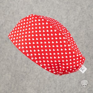 May include: Red fabric scrub cap with a white heart pattern.
