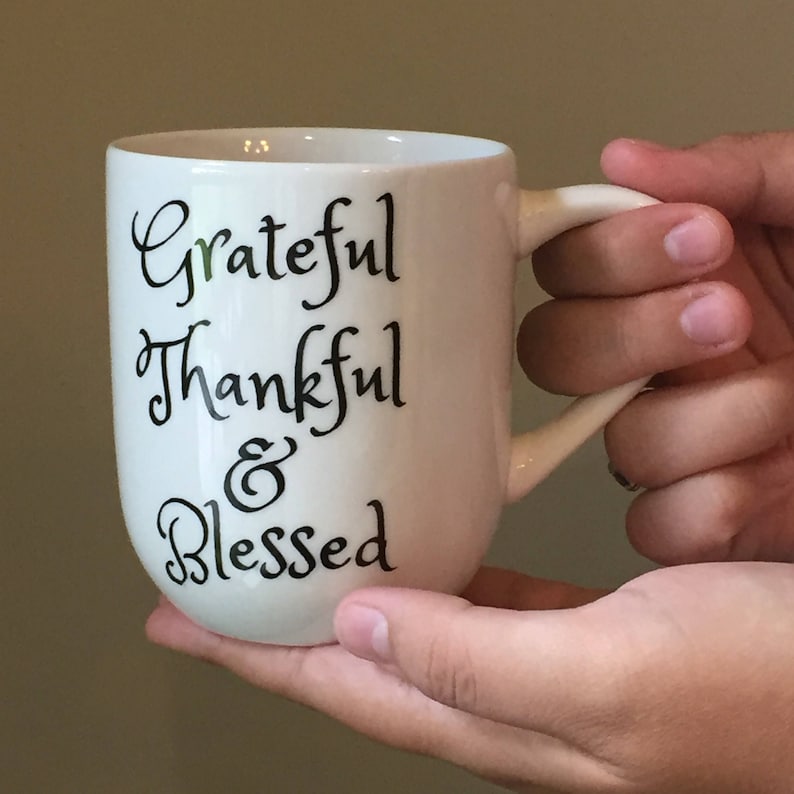 May include: White ceramic coffee mug with black lettering that reads "Grateful Thankful & Blessed".