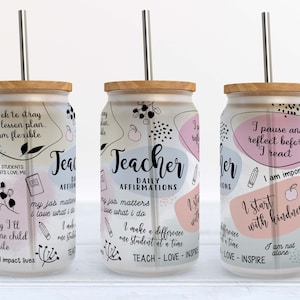 May include: Three white reusable tumblers with a wood lid and a stainless steel straw. Each tumbler has a different design with black text and illustrations. The text on the tumblers reads "Teacher Daily Affirmations", "I pause and reflect before I react", and "I start with kindness".