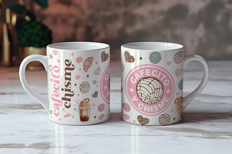 May include: Two white ceramic mugs with pink and brown designs. One mug features the text "Cafecito y chisme" and the other mug features the text "Cafecito y chisme" in a circle with a pastry design.