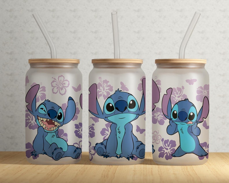 Może przedstawiać: Trzy szklane kubki z bambusowymi pokrywkami i przezroczystymi słomkami. Każdy kubek przedstawia inny obraz postaci z kresk&oacute;wki Stitch w r&oacute;żnych pozach, otoczonego fioletowymi kwiatami hibiskusa. Kubki są matowe.