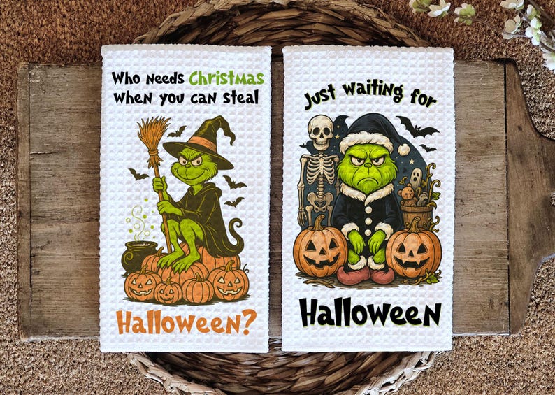 May include: Two white waffle-weave kitchen towels with Halloween designs. One shows a green character in a witch hat, with the text "Who Needs Christmas When you can steal Halloween?" The other shows a green character in a Santa hat, with the text "Just waiting for Halloween."
