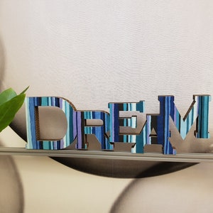 DREAM. Allegra decorazione per la casa. Cartone decorato a strisce multicolori. Appendere al muro o appoggiare su un mobile. Leggerissima