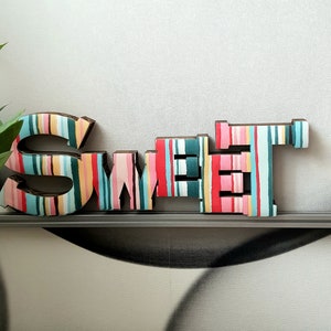 SWEET. Allegra decorazione per la casa. Cartone decorato a strisce multicolori. Appendere al muro o appoggiare su un mobile. Leggerissima