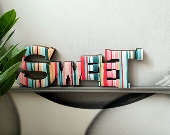 SWEET. Allegra decorazione per la casa. Cartone decorato a strisce multicolori. Appendere al muro o appoggiare su un mobile. Leggerissima