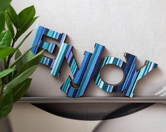 ENJOY. Allegra decorazione per la casa. Cartone decorato a strisce multicolori. Appendere al muro o appoggiare su un mobile. Leggerissima