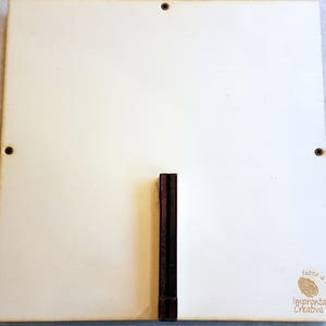 Puede incluir: Un letrero cuadrado de madera blanca con un soporte de madera marr&oacute;n. El letrero tiene un peque&ntilde;o sello marr&oacute;n que dice "fatto a mano" e "Impronta Creativa".