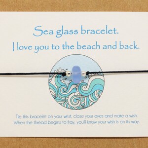 May include: A sea glass bracelet with a blue glass bead and black string. The card reads "Sea glass bracelet. I love you to the beach and back. Tie this bracelet on your wrist, close your eyes and make a wish. When the thread begins to fray, you'll know your wish is on its way."