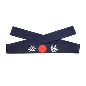 May include: A navy blue headband with a red circle and white Japanese characters that read "疾風" (meaning "swift wind").