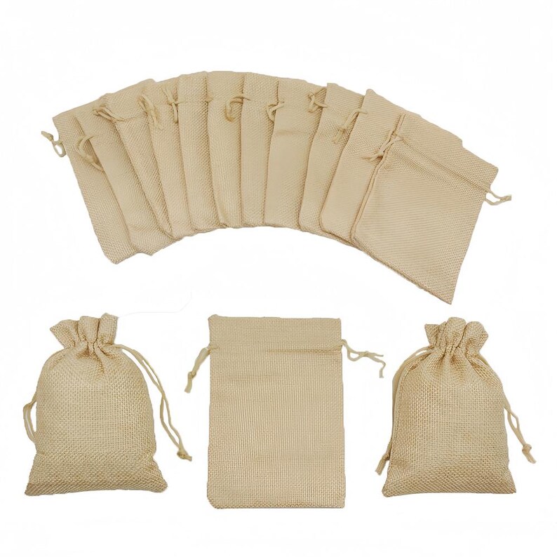 May include: Beige burlap drawstring bags. The image shows a fan of bags and a few individual ones. The bags are made of woven fabric, with a natural, rustic look. The bags have a drawstring closure.