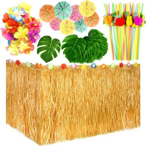 Puede incluir: Un conjunto de decoraciones para fiestas de luau que incluye una falda de mesa de paja dorada, hojas de palma verdes, sombrillas de papel de colores y collares de flores de colores.