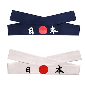 May include: Two fabric headbands featuring the Japanese flag and the word "Japan" in white lettering. The top headband is navy blue and the bottom headband is white.