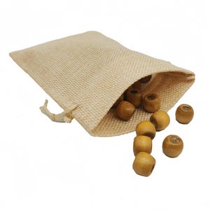 May include: A beige hessian drawstring bag with light brown wooden beads spilling out. The beads are cylindrical with a hole through the centre. The bag is open, and the beads are scattered around it.