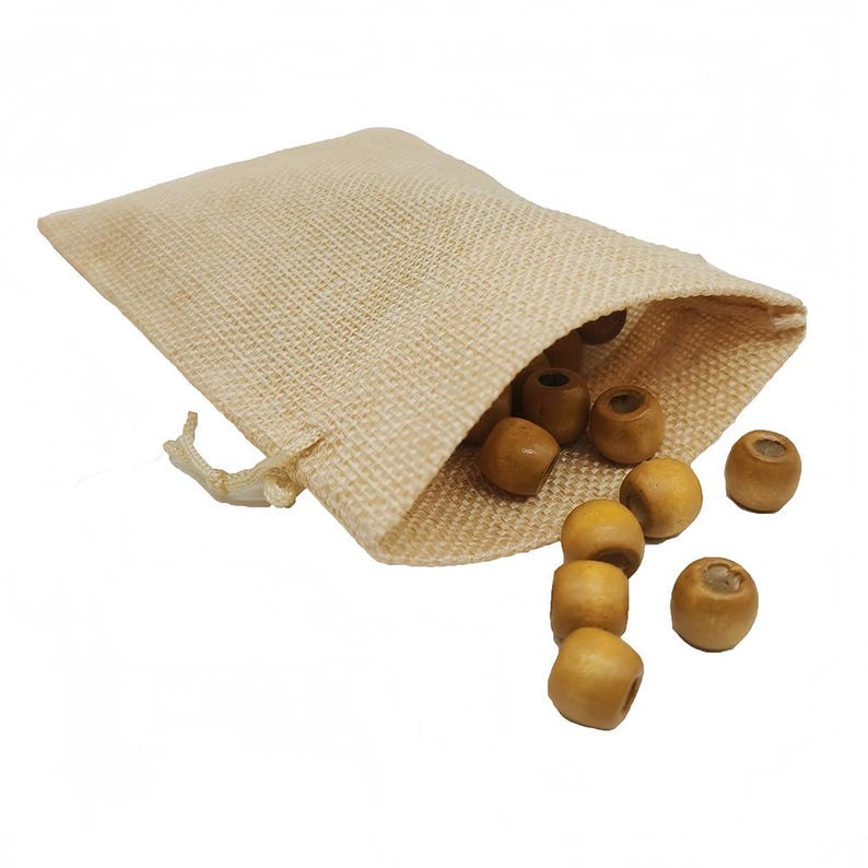May include: A beige hessian drawstring bag with light brown wooden beads spilling out. The beads are cylindrical with a hole through the centre. The bag is open, and the beads are scattered around it.