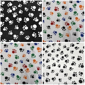 May include: Four fabric swatches with paw print patterns. One swatch is black with white paw prints. The other three swatches are white with colorful paw prints in red, orange, green, and blue.