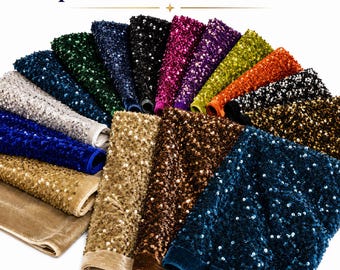 May include: A collection of Sequins Stretch Velvet Fabric swatches arranged in a fan shape. The fabric pieces feature various colors including gold, silver, blue, green, black, purple, yellow, orange, and brown, all covered in reflective sequins.