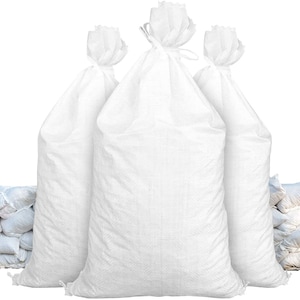 May include: Three large white sandbags, with two in the front and one in the back. The sandbags are made of woven polypropylene and have a drawstring closure. There are several smaller sandbags in the background.