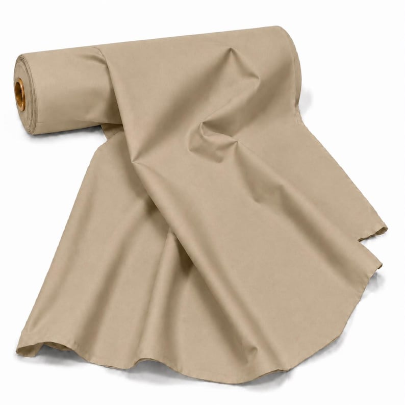 May include: A large roll of solid beige fabric featuring a smooth, matte texture. The fabric is partially unrolled, creating soft, flowing folds that drape downward from the central cylindrical cardboard core, displaying a consistent light tan colour.