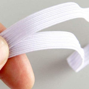 May include: White elastic band with a ribbed texture. The band is folded in half, showing the inside of the band.