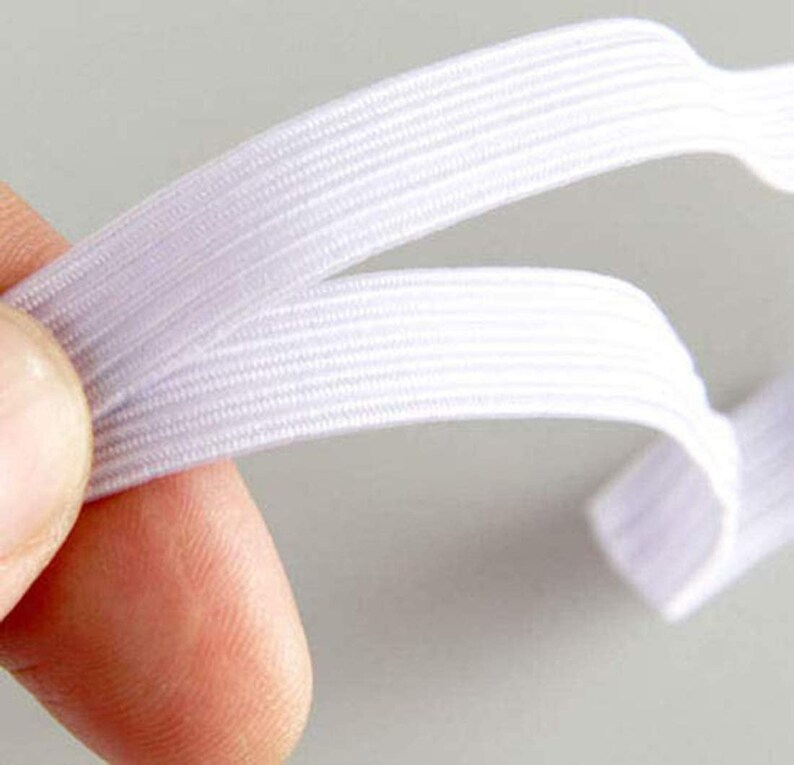 May include: White elastic band with a ribbed texture. The band is folded in half, showing the inside of the band.