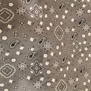 May include: Gray fabric with a white paisley pattern. The fabric has a repeating pattern of paisley shapes, diamonds, and small dots.