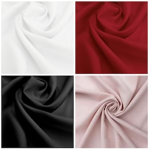 May include: Four fabric swatches in a square arrangement. The colors are white, deep red, black, and a pale pink. The fabric is draped and swirled, showing the texture and flow of the material.