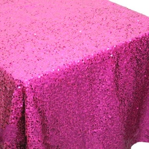 May include: A bright pink sequin tablecloth. The tablecloth is made of a soft, shimmery fabric that is perfect for adding a touch of glamour to any event.