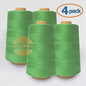 May include: Four spools of bright green thread, each with a wooden bobbin. The spools are arranged in a row, with the text "4 pack" visible above them.