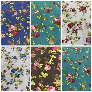 May include: A collection of floral fabric swatches in various colors. The fabrics feature a repeating pattern of roses and foliage in shades of pink, red, and green, set against backgrounds of blue, teal, gray, and brown. The floral design is a classic, timeless pattern.