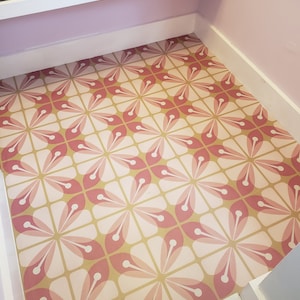 Op de afbeelding: Een roze en beige betegelde vloer met een geometrisch ontwerp. De tegels zijn in een herhalend patroon gerangschikt.