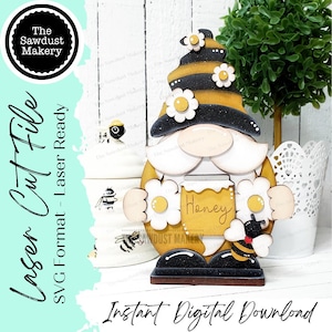 May include: A wooden gnome figurine with a black and yellow striped hat, holding a honey jar with the word "Honey" on it. The gnome is surrounded by white flowers and a bee.