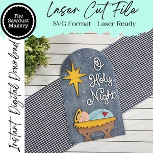 May include: A laser cut file design for a wooden sign with a blue background, a yellow star, and the text "O Holy Night". A baby Jesus in a manger is depicted at the bottom of the sign.