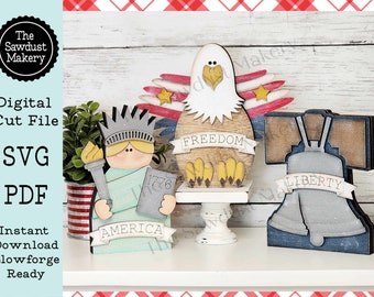 May include: Three wooden cutouts with patriotic themes: a Statue of Liberty with "AMERICA" and "1776" on it, a bald eagle with "FREEDOM" on a banner, and a Liberty Bell with "LIBERTY" on a banner. The cutouts are on a white shelf.