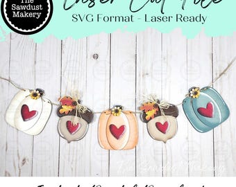 May include: A digital laser cut file featuring a garland of five decorative shapes including pumpkins and acorns. Each shape is adorned with a red heart, a small sunflower, and twine. The text reads Laser Cut File, SVG Format - Laser Ready, and Instant Digital Download.