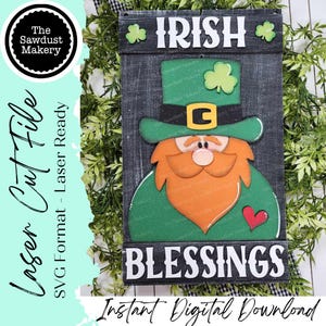 Puede incluir: Un letrero de madera con un diseño de duende. El letrero presenta las palabras "IRISH BLESSINGS" y "Instant Digital Download". El duende tiene un sombrero y abrigo verdes, una barba naranja y un corazón rojo.