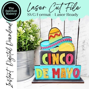 Pode incluir: Um arquivo de corte a laser para um sinal de Cinco de Mayo. O sinal é feito de madeira e apresenta um sombrero, tacos e as palavras "Cinco de Mayo".