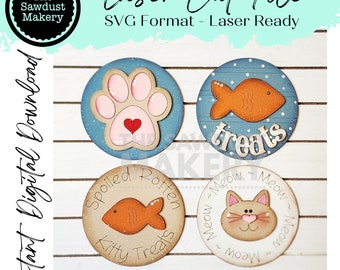 May include: Four laser cut wooden circles with different designs. The first circle has a pink paw print with a red heart in the centre. The second circle has an orange fish with the word "treats" below it. The third circle has an orange fish with the words "Spoiled Rotten Kitty Treats" around it. The fourth circle has a cat face with the words "Meow Meow Meow Meow" around it.