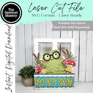 May include: A laser-cut wooden window box insert featuring a green frog wearing glasses, mushrooms, and cattails. The box has the words "HOP INTO SPRING" in yellow and blue. The image also includes the text "Laser Cut File" and "Instant Digital Download".