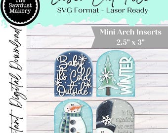 May include: A digital download featuring four mini arch inserts with winter-themed designs. The inserts, measuring 2.5" x 3", include phrases like "Baby it's Cold Outside" and "Winter", along with snowman and Christmas tree illustrations. The file is laser-ready.