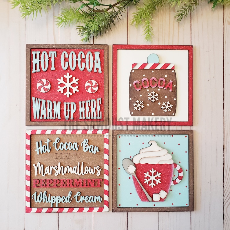 May include: Four wooden signs with a winter holiday theme. The signs feature red and white candy canes, snowflakes, and a cocoa mug with whipped cream. The text on the signs reads "Hot Cocoa Warm Up Here", "Hot Cocoa Bar Menu Marshmallows Peppermint Whipped Cream", and "Cocoa".