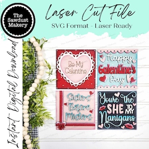 May include: Four laser cut Valentine's Day signs with different sayings. The signs are red, pink, blue, and black with white lettering. The sayings are "Be My Galentine", "Happy Galentine's Day", "Sisters Before Misters", and "You're the SHE to My Nanigans".